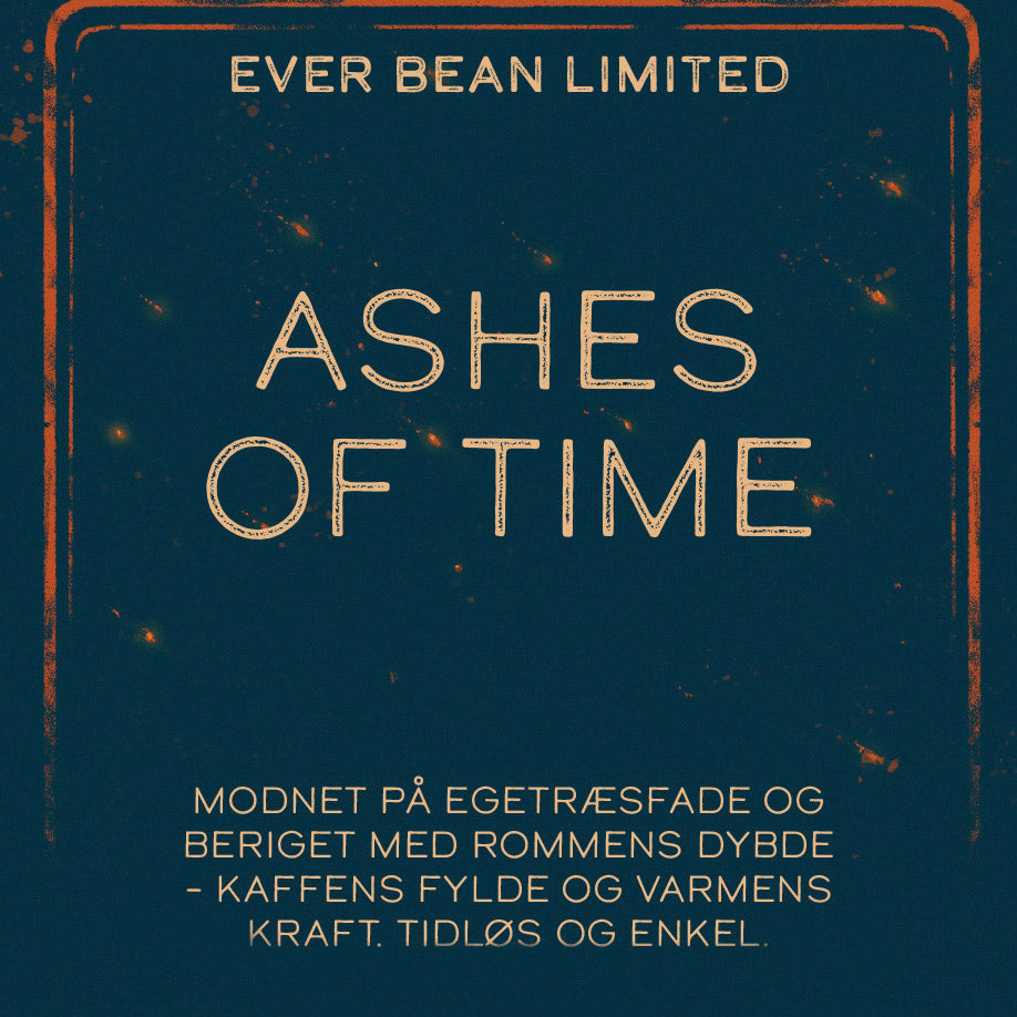 En etiket i vintage-stil lyder: "EverBean Limited, Ashes of Time, ICED Coffee Blend" med dansk tekst om kaffe lagret på egetræsfade med romrigdom – fyldig og varm – på en mørkeblå baggrund.
