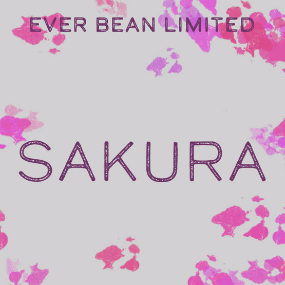 Teksten på en lys baggrund lyder "EverBean Limited" øverst og "Limited, Sakura (øko)" med store bogstaver i midten, med lyserøde stænk i akvarelstil inspireret af sakura kaffe og Honduras arabica bønner rundt i kanterne.