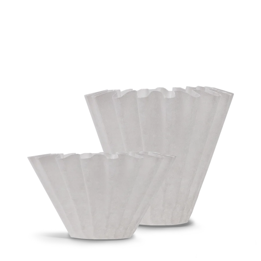 To hvide, riflede kaffefiltre vises på en almindelig baggrund, hvor det ene står lidt foran og kortere end det andet. Filtrene har et plisseret design og bruges til dryp kaffemaskiner.
