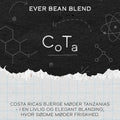 På en kaffeetiket i kridttavlestil står der "CoTa" og "EverBean". Nedenfor, på dansk: "Costa Rica kaffe møder Tanzania kaffe - i en livlig og elegant kaffeblanding, hvor sødme møder friskhed.