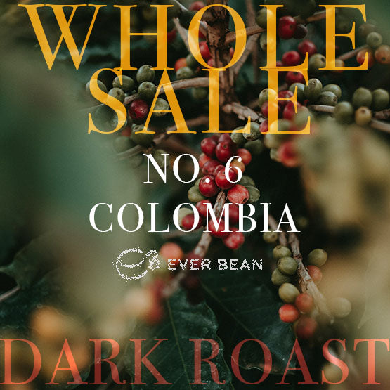 Modne og umodne kaffekirsebær på en gren med grønt løv og overlagt tekst: "WHOLESALE EVERBEAN NR. 06 · COLOMBIA DARK ROAST".