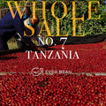 To personer sorterer røde Tanzania-kaffekirsebær på en måtte udendørs. "EverBean Wholesale"-logoet og teksten "No. 07 - Tanzania (w)" vises over billedet.