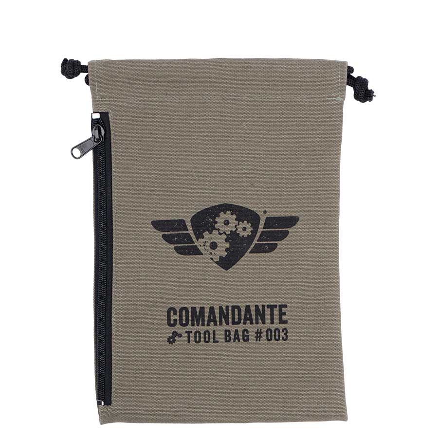 Comandante Toolbag #3 fra Comandante er en khakifarvet lærredstaske med lynlås i siden, snørelukning og et trykt gear- og vingelogo samt "COMANDANTE TOOL BAG #003" - ideel til dine vigtigste ting eller Comandante-sliberen.