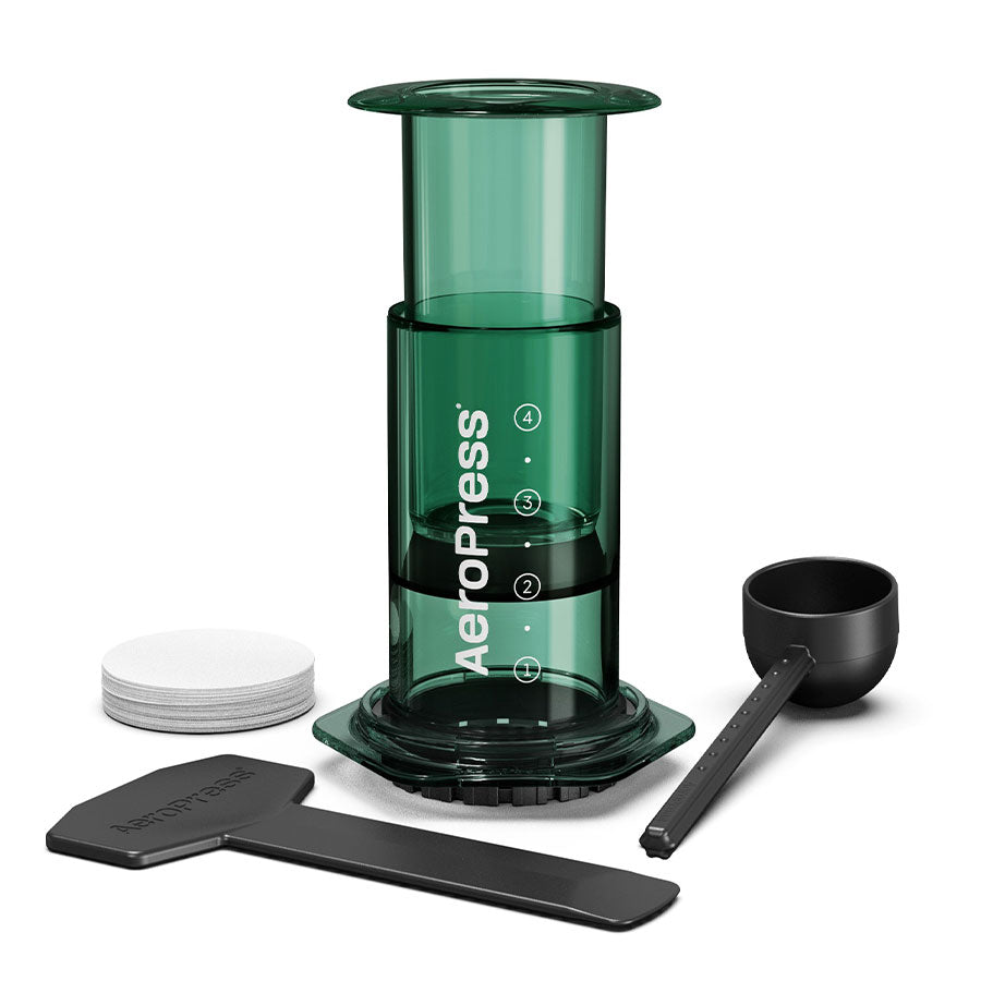 AeroPress Limited kaffebrygger fra Aeropress i grønn med tilbehør-rører, måleskje, papirfilter og filterholder-arrangementert på hvit bakgrunn. Perfekt som bærbar kaffebrygger med innovativ bryggeteknologi.