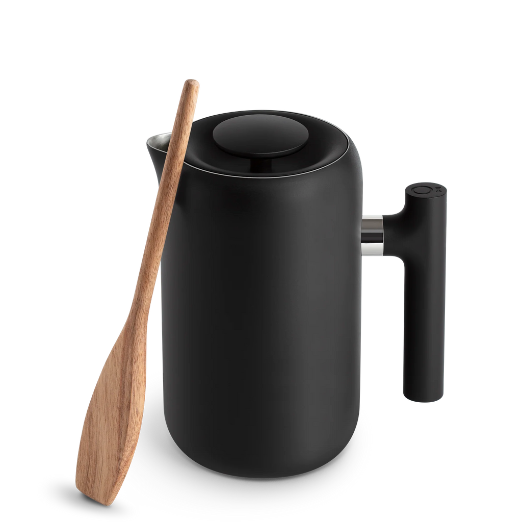 Fellow's Clara French Press i sort har forbedret mesh-filtrering, en mat finish og et ergonomisk håndtag, der perfekt komplementerer den naturlige trærører ved siden af.