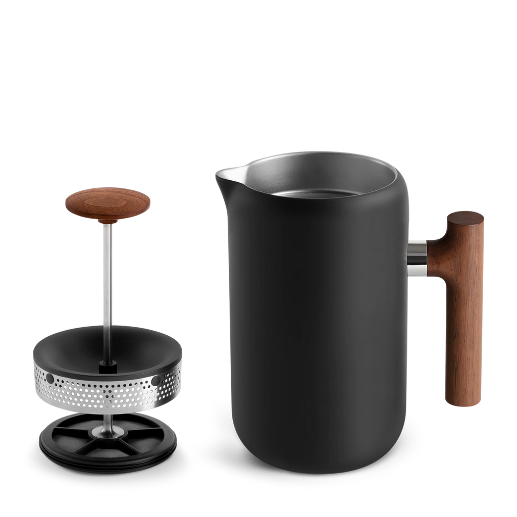 Fellow Clara French Press, Valnød, fra Fellow har et slankt matsort design med et træhåndtag. Den har vakuumisolerede vægge og en nonstick-underside for perfekt brygning. Låget og stemplet med deres træknopper afslører dets indre af rustfrit stål.