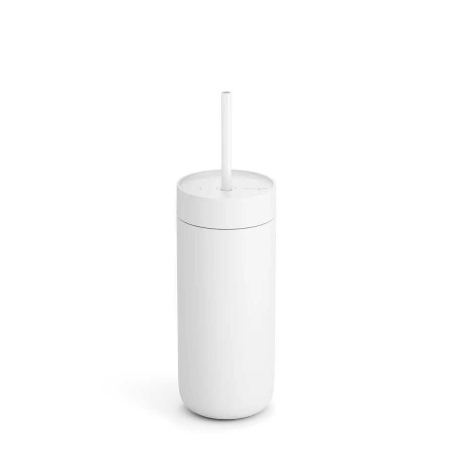 Fellow Carter Cold Tumbler, et iskaffe rejsekrus, har et højt hvidt isoleret design med True Taste keramisk belægning. Den kommer med et matchende sugerør og låg og sidder på en almindelig baggrund og kaster en blød skygge til venstre.