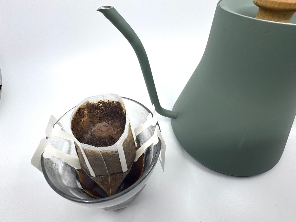 No. 02 - Brasilen, Øko, Single Serve fra EverBean ApS. har en grøn svanehals-kedel og glasdråber til frisk Arabica-kaffe - hæld bare varmt vand over kaffegrumset for at få en perfekt kop hver gang.