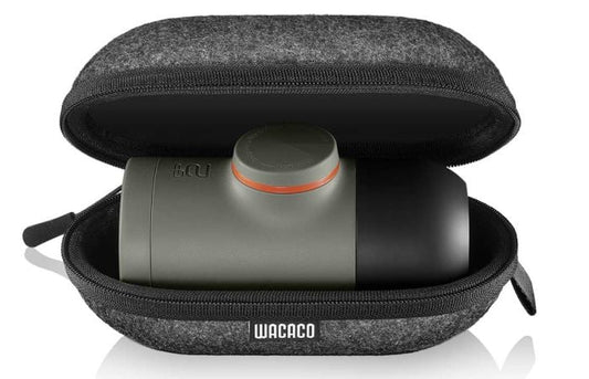 Wacaco Minipresso NS2, i olivengrøn, er en kompakt espressomaskine opbevaret i en grå lynlåsetui, der har "Wacaco" på fronten og en blød foring til at beskytte den.