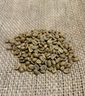 En samling grønne kaffebønner, med den udsøgte "301 · Burundi, Grønne Bønner" fra EverBean, hviler på en tekstureret jutestofbaggrund.