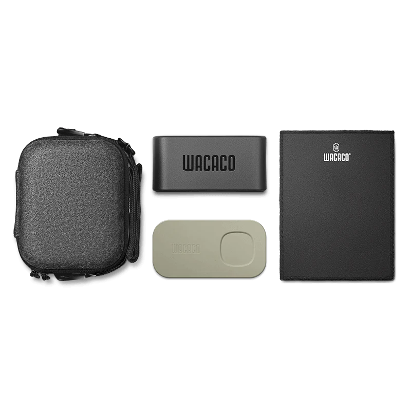Minipresso NS2 Case fra Wacaco er et kompakt rejse-espressosæt med en tekstureret sort bæretaske, en Wacaco-mærket sort kaffebeholder, et beige tilbehørsstykke og en Wacaco-mærket sort måtte. Den er perfekt til dine behov for kapsel-espressomaskine på farten.