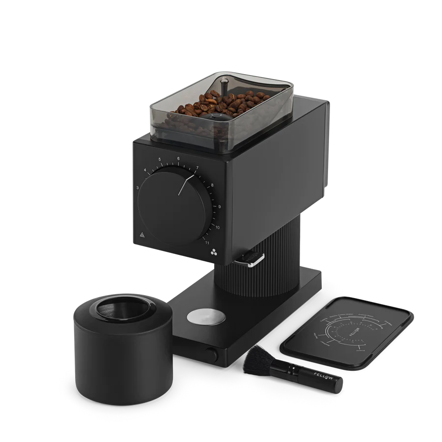 Fellow Ode Brew Gen 2 Kværn er en moderne sort kaffekværn med Gen 2 Brew Burr-teknologi, med en klar bønnebeholder på toppen og drejeknapper på fronten. Den leveres med sort børste, cylindrisk tilbehør og rektangulær måtte med kaffebryggemetodevejledning.