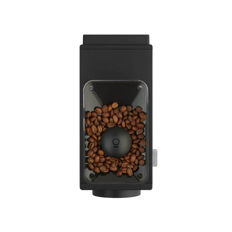 Set ovenfra af en Fellow Ode Brew Gen 2 Kværn kaffekværn fyldt med brune bønner. Det slanke sorte rektangulære design har antistatisk teknologi og et gennemsigtigt vindue, der viser bønner omkring den centrale slibemekanisme.