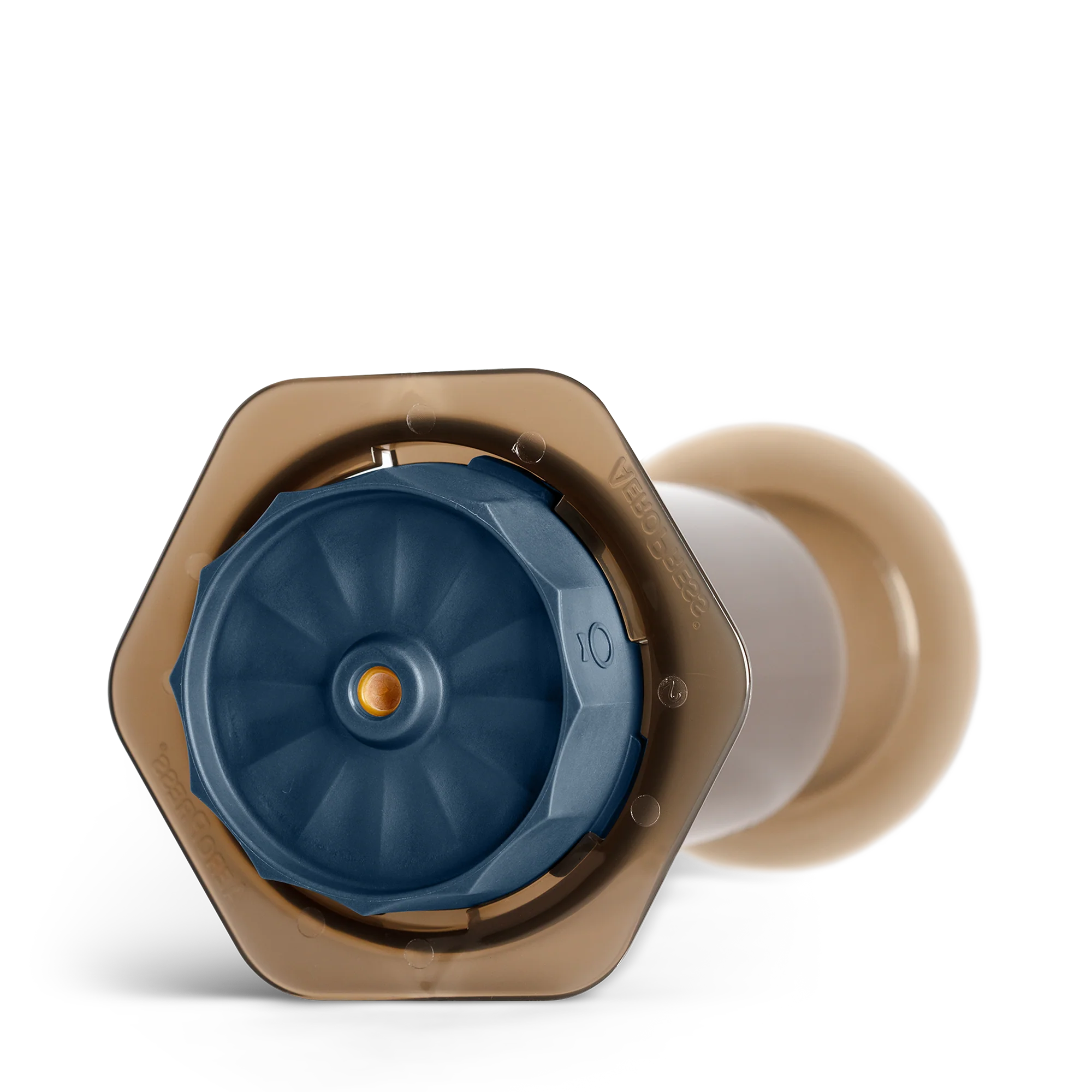 Et nærbillede af en blå og beige kaffekapsel, der ligner Prismo-designet af Fellow, set fra oven. Den har en sekskantet beige ramme med en central blå komponent og en lille orange prik på en reflekterende sort overflade, ideel til Fellow Prismo Attachment til AeroPress eller espresso-stil kaffe.