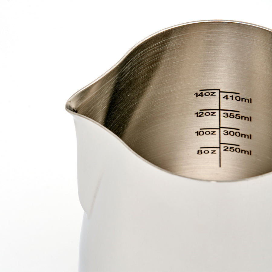 Rhino Coffee Gear Pro Milk Pitcher fra Rhino Coffee Gear har tydelige indvendige markeringer fra 250 ml (8 oz) til 410 ml (14 oz), en glat finish i rustfrit stål og en præcis tud, der gør det nemt at hælde.