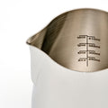 Rhino Coffee Gear Pro Milk Pitcher fra Rhino Coffee Gear har tydelige indvendige markeringer fra 250 ml (8 oz) til 410 ml (14 oz), en glat finish i rustfrit stål og en præcis tud, der gør det nemt at hælde.
