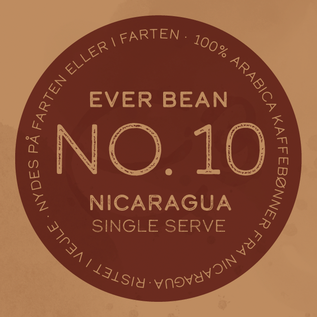 På en cirkulær kaffeetiket står der: "EverBean ApS. No. 10 Nicaragua, Single Serve." Rundt i kanten: "100% Arabica kaffebønner fra Sajonia Estate Coffee - nicaraguansk kaffe, nydes på farten eller i værtshjem.