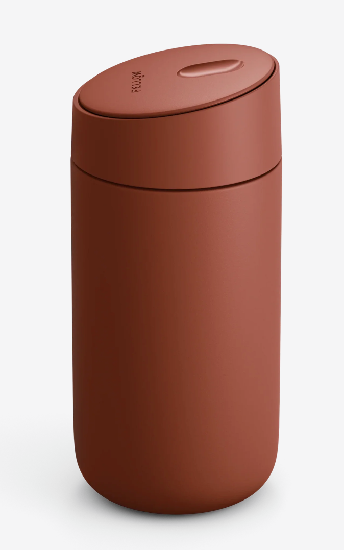 Et mat, rustfarvet Fellow Carter Slide Mug Termo Krus med cylindrisk form, afrundet låg og diskret fordybning i toppen er afbilledet mod en almindelig hvid baggrund.