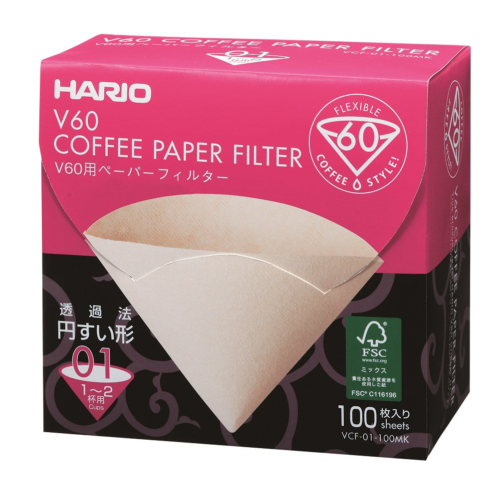 Hario Papir Filter Størrelse 01 æsken har et pink, sort og hvidt design med "V60 KAFFEPAPIRFILTER", "FLEKSIBEL KAFFESTIL!" og "100 ark" trykt på den. Et billede af et papirfilter viser dets kaffebrygningsoplevelse fremtrædende.