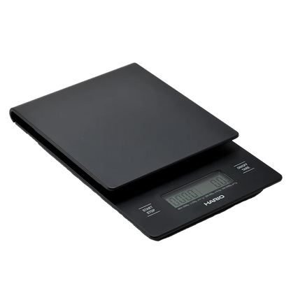 Hario V60 Drip Vægt er en elegant sort digital køkkenvægt med LCD-display og nuller. Den har strøm-, timer- og taraknapper under "Hario"-mærket, ideel til præcis V60-skænkning af kaffe.