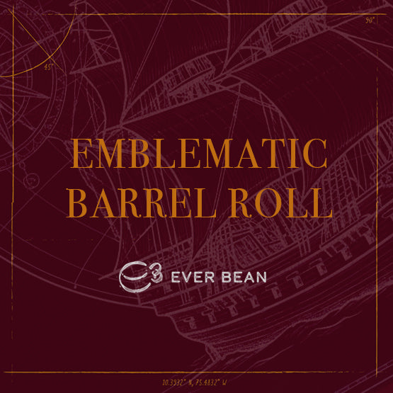 Rødbrun baggrund med en svag kontur af et sejlskib. Den gyldne tekst lyder: »Limited · Emblematic Barrel Roll · Filter, Chemex og Stempel« af EverBean Limited. Nedenfor fuldender et stiliseret »e3«-logo og »EVER BEAN« i hvidt designet.