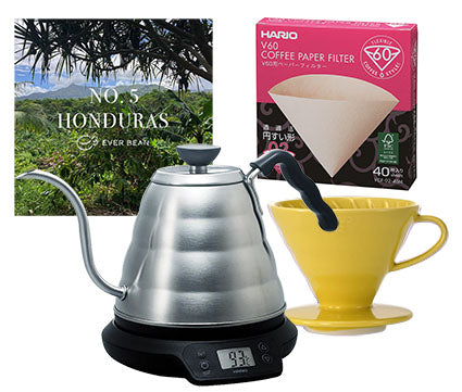 Billede, der viser et naturskønt Honduras-foto med Startup · Filter, Medium fra EverBean, en gul V60-drypper, kedel i rustfrit stål og digital vægt. Perfekt til Pour-Over Kaffe elskere, der søger fremragende brygning.