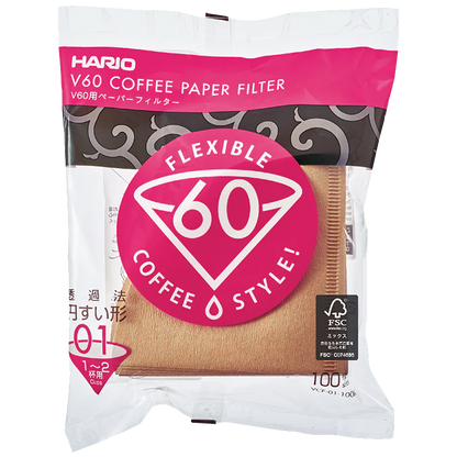 Hario Papirfiltre fra Hario til V60, størrelse 01 (1-2 kopper), i hvid og lyserød emballage med stort V60-logo. Indeholder brune, biologisk nedbrydelige kaffefiltre i kegleform.