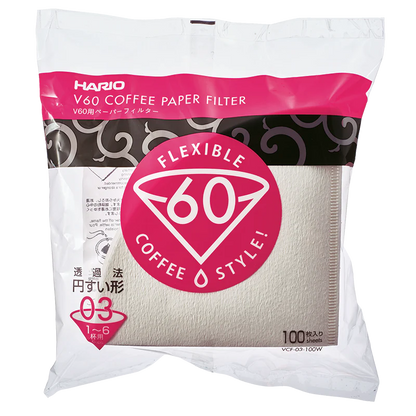 Hario Papirfiltre V60, størrelse 03. Pakke med 100 biologisk nedbrydelige naturhvide filtre i hvid og pink emballage med "V60 Flexible Coffee Style!" logo fra Hario.