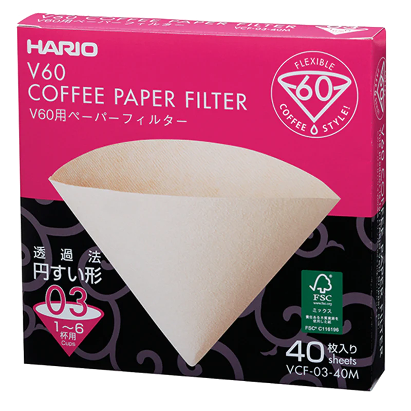En æske Hario Papirfiltre, biologisk nedbrydelige V60-kaffefiltre til 1-6 kopper (model VCF-03-40M), har en pink og sort emballage med et billede af et enkelt kegleformet filter og indeholder 40 ark.