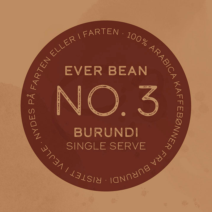 På en brun cirkulær etiket står der "Single Serve (w)" fra EverBean Wholesale med dansk og engelsk tekst om Limited kaffe lavet af 100 % Arabica Single Origin-bønner fra Burundi.