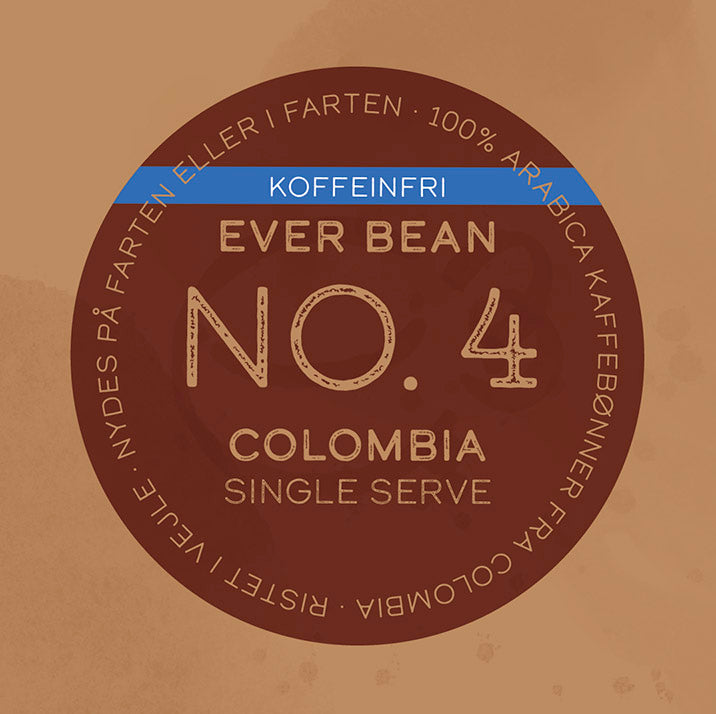En brun cirkulær kaffeetiket viser "No. 04 - Colombia, Øko, Decaf, Single Serve" fra EverBean ApS, med et blåt "KOFFEINFRI"-banner og tekst om 100% Arabica colombiansk kaffe - ideel som single serve til enhver lejlighed.