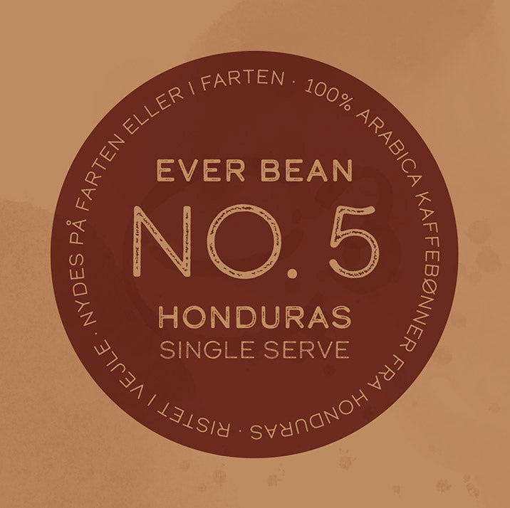 På en rund, brun etiket står der: "EverBean Wholesale Single Serve (w)" i midten, og rundt om kanten står der "100% Arabica kaffebønner fra Honduras", hvilket fremhæver denne limited kaffe som single origin kaffe på dansk.