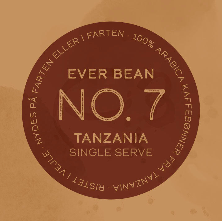 En rund kaffeetiket med "No. 07 - Tanzania, Single Serve" af EverBean ApS. i midten. På kanten står der: "100% vasket Arabica kaffebønner fra Tanzania kaffe. Ristet i Norge. Nydes på farten eller i farten.